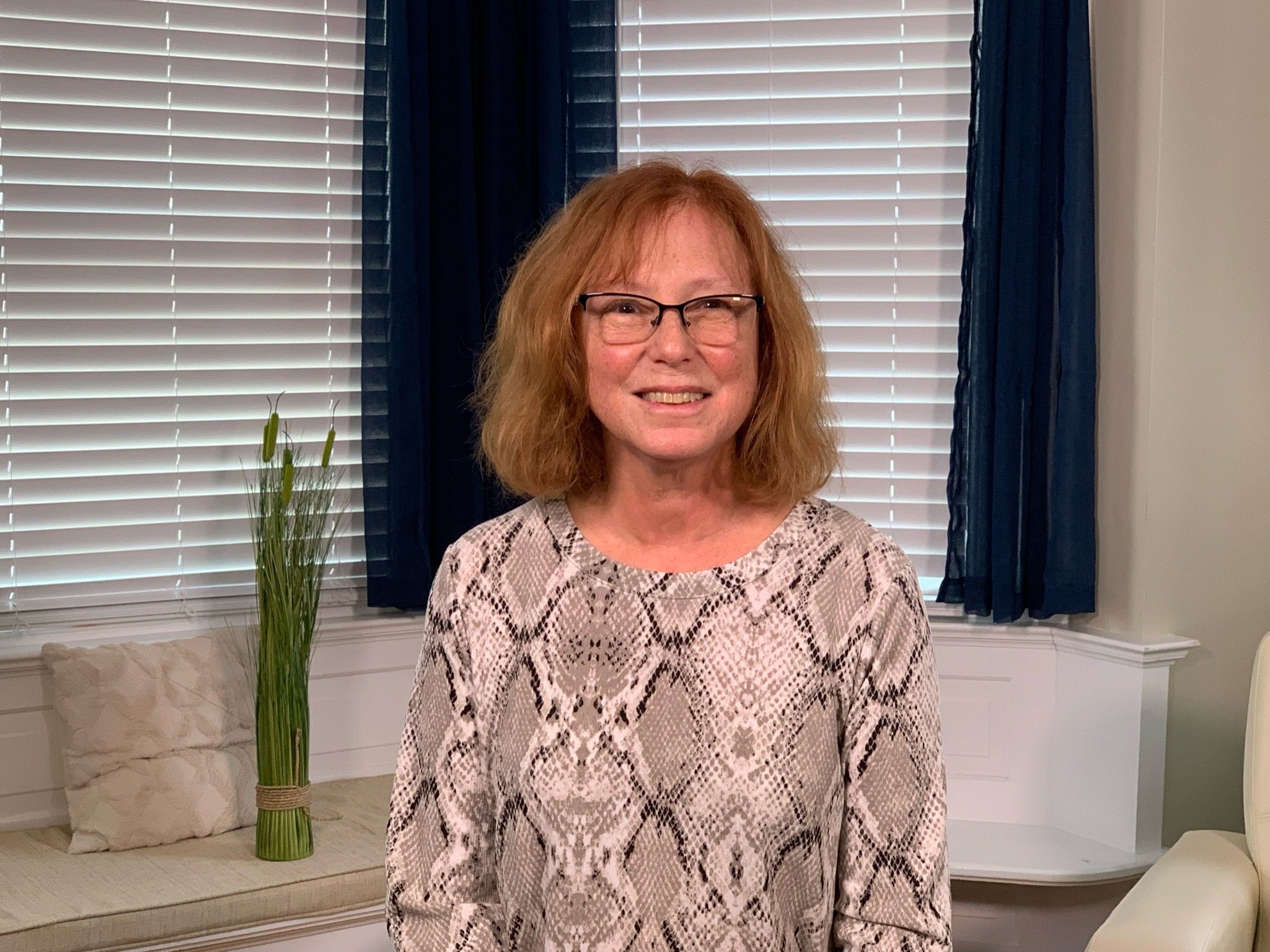 Diane Elliot poses for a headshot in a living room